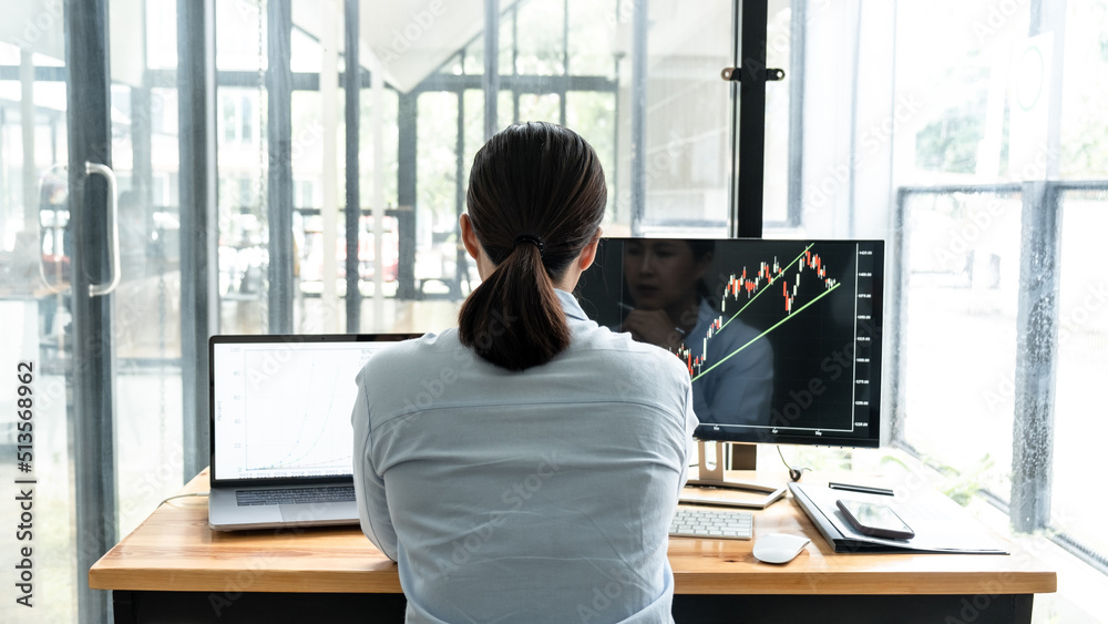 Poster Businesswoman investor having planning and analyzing graph data with display screen the data presented and deal on a stock exchange