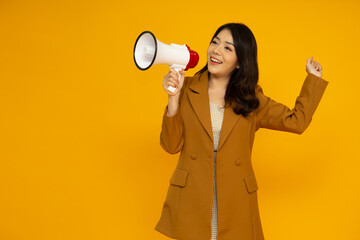 Fototapeta Young Asian business woman holding megaphone isolated on yellow background, Speech and announce concept obraz