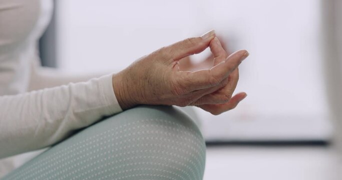 Closeup hand and fingers of a mature woman meditating at home in the lotus position. Senior adult practicing yoga. One retired female finding balance and inner peace. Mindful of her body and mind