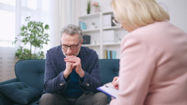 Man in his 50s talking with psychologist, seeking mental health help, depression