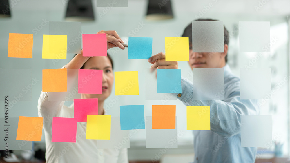 Poster two business executive team holding and taking notes keyword on board wall to brainstorm about a new