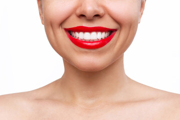 Obraz premium Cropped shot of young caucasian smiling woman with the even teeth isolated on a white background. Perfect smile with red lipstick. Teeth whitening. Oral hygiene, dental health care