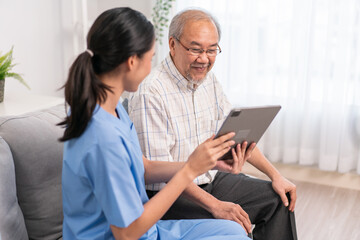 Asian nurse showing health checkup report to grandfather and giving advice. medical assisted living visit senior patient at home. Home nursing and healthcare caregiver concept