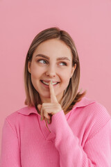 Fototapeta premium Portrait of young beautiful girl showing silence gesture