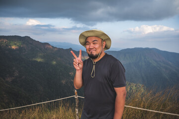 Asian fat man with beautiful view of khao San nok wua mountain kanchanaburi.Khao San Nok Wua is the...