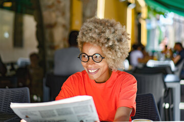 Attractive woman reading a newspaper at outdoor cafe