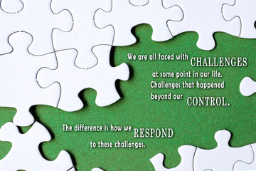 Motivational quote on white jigsaw with some missing pieces on green background.