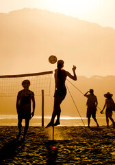 Silhouette of people playing footvolley on the Camburi beach, Brazil
