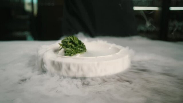 pastry chef pouring liquid nitrogen over sorrel dessert