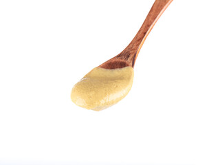 Wooden spoon with Dijon mustard isolated on white background.