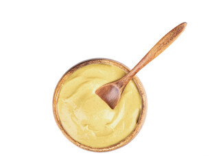 A wooden bowl with Dijon mustard and a wooden spoon inside the mustard.