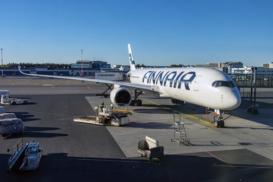 HELSINKI, FINLAND, JUNE 16 2022,The airplane Finnair is parking beside tunnel in the international airport Helsinki.