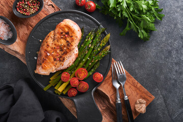 Chicken breast grilled with vegetables. Grilled chicken steak, asparagus and cherry tomatoes in...