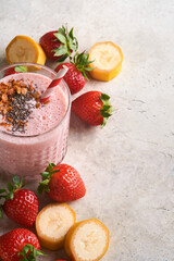 Strawberry smoothie. Vegan smoothie or milkshake from strawberry, banana and mint on white wooden table background. Clean eating, alkaline diet. Top view. Mock up.