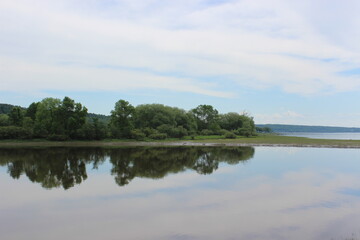 Fototapeta na wymiar Reflection on St Lawrence River Shore in Portneuf, Qc