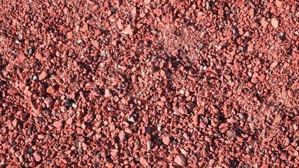 Building materials and fettling background, red crushed brick. Background texture of stone, crushed stone and brick