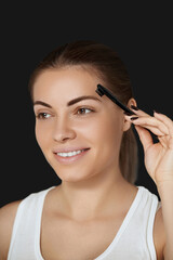 Beauty makeup. Eyebrows Care. Beautiful woman shaping brows with comb.  Correcting and contouring eyebrows.