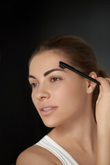 Obraz premium Beauty makeup. Woman shaping eyebrow closeup. Girl model with professional makeup contouring eyebrows