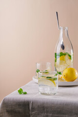 Refreshing summer drink with lemon and mint on the table. Lemonade in glasses and bottle