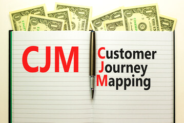 CJM customer journey mapping symbol. Concept words CJM customer journey mapping on white note on a beautiful white background. Dollar bills. Business CJM customer journey mapping concept. Copy space.