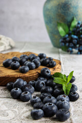 Fresh blueberries and some mint on the table falling from the bred