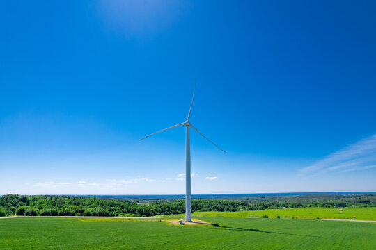 Panoramic shot from a bird's eye view of wind turbines in the middle of fields. Wind turbine construction in green field blue sky to generate renewable clean energy. concept idea eco energy energy.