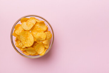 Potato chips on bowl isolated on colored background. Delicious crispy potato chips in bowl. Space for text. Top view