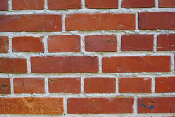 Closeup of a brick wall with cement and rough texture on a home or house. Details of modern architecture on of a residence or building as a background. Solid red brickwork on a wall