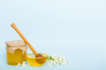 robinia honey bollte with acacia blossoms on colored table