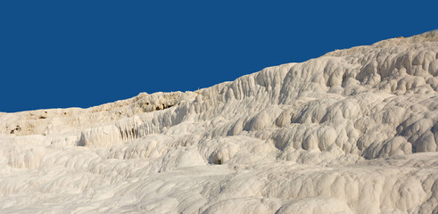 Fototapeta na wymiar Landscape of the Travertine pools and terraces in Pamukkale Turkey. Desert sand with textured pattern against a blue sky. Tourism holiday destination at rock cotton castle location during hot springs