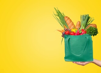 Online grocery shopping and home delivery, a bag full of groceries - obrazy, fototapety, plakaty