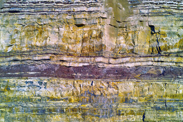 Background of textured layers of earth, sedimentary minerals and stones. Mining underground...