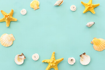 Fototapeta na wymiar nautical concept seashells and starfish over mint blue wooden background