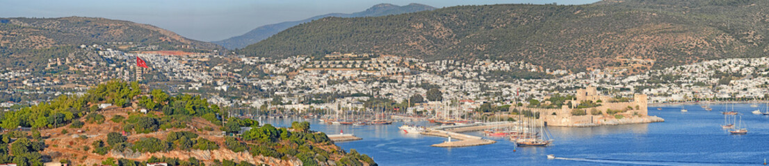 Fototapeta na wymiar Panorama view of city and hills in romantic harbor of Bodrum in Turkey during the day. Scenic landscape view of sailing yachts in cruise port and bay. Tourism abroad, overseas in Aegean sea dockyard