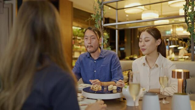 Group of asian people having dinner at an upscale restaurant. They enjoy with dinner together.