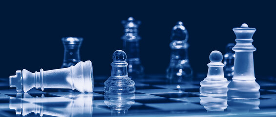 Glass chess on chess board. Photographed up close with the black background.