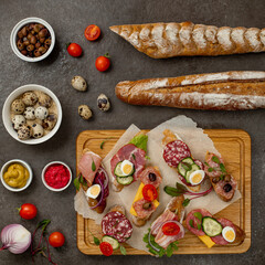 Sandwiches on a dark background, or assorted canapes or pintxos, tapas. Copy space. Concept party food or blog ingredient.