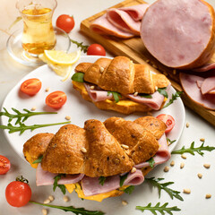 Herbal tea and two Croissant sandwich with hamon and chees on plate. Morning breakfast. White backgrounds