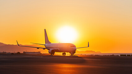 Private jet on runway airport at sunset - 513596754