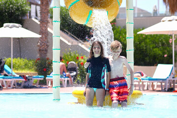 Happy teenage kids having fun in aqua park during summer vacation - 513596755