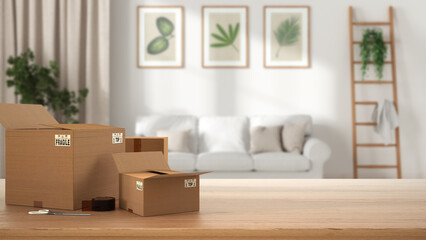 Wooden table, desk or shelf with stack of cardboard boxes over blurred view of white scandinavian living room with sofa, modern interior design, moving house concept with copy space