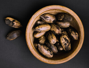 bowl of pecans nuts on black  background