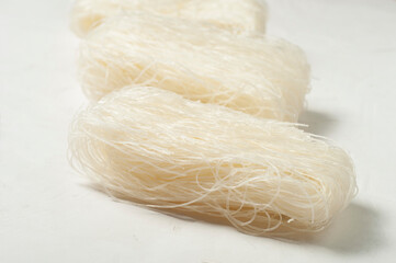 raw Korean starch tangen noodles on a gray background, side view, close-up selective focus.