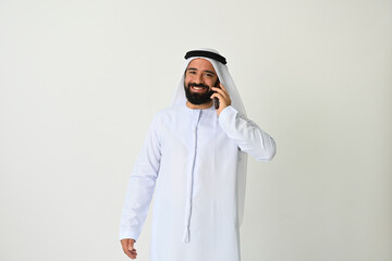 Arab Emirati man on mobile phone talking or calling wearing traditional. Arabian Muslim businessman using smart phone