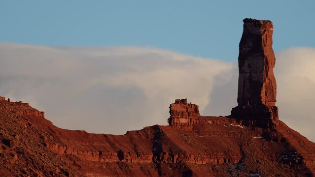 View of Castleton Tower as clouds move by in timelapse at sunset near Moab Utah.