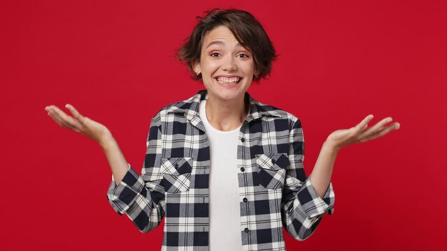 Fun young brunette woman 20s she wearing basic white t-shirt checkered shirt looking shocked wow show hands brain explosion head isolated on plain solid dark red color wall background studio portrait