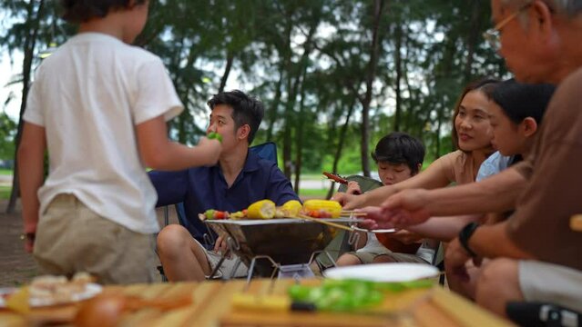 Happy family preparing barbecue together, Cooking grilled bbq dinner outside beach, enjoy summer on the beach enjoy on weekend people lifestyle.