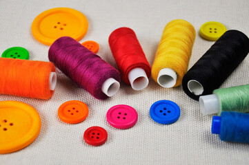 Sewing thread spools and multicolored buttons.