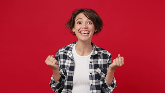 Smiling good kind surprised happy young woman 20s she wears casual clothes ask who me oh it so sweet put hands on chest isolated against over plain solid dark red color wall background studio portrait