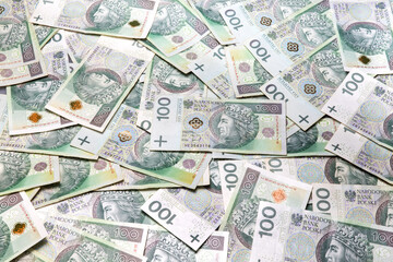 banknoty stuzłotowe rozrzucone na stole w dużej ilości  - 513603981